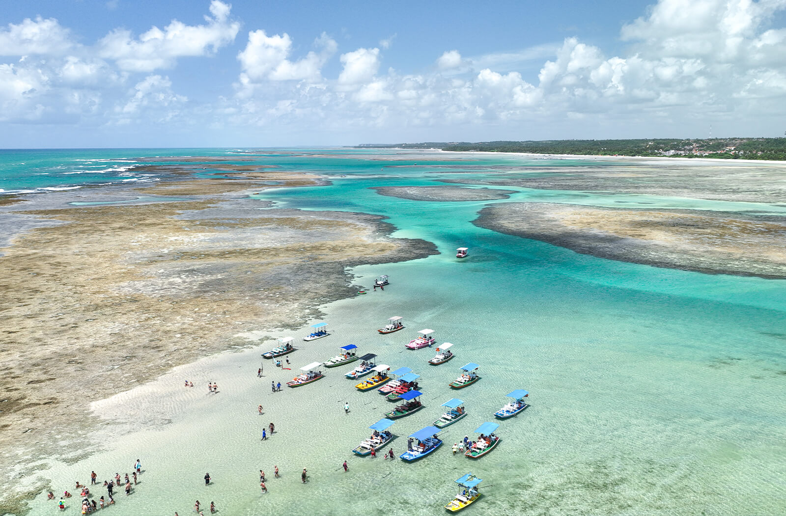 barcos parados e reunidos nos corais com a maré baixa para que as pessoas possam contemplar as belezas naturais.
